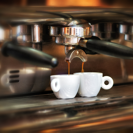 Ein italienischer Espresso darf zu keinem Essen in Italien fehlen. Auf dem Bild siehst du, wie zwei Tassen Espresso in einer typisch italienischen Espressomaschine hergestellt werden.